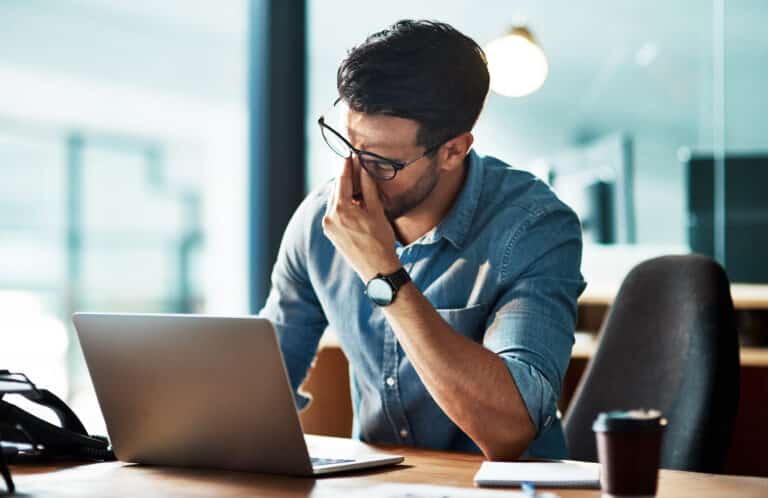 A frustrated business owner looks at their computer.