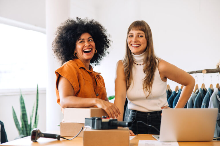 Two e-commerce business owners processing online store orders for shipping.