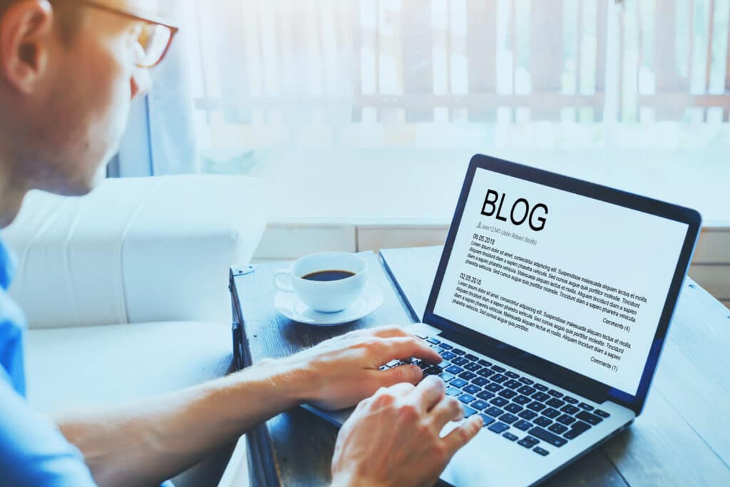 A man writing a blog on his laptop.