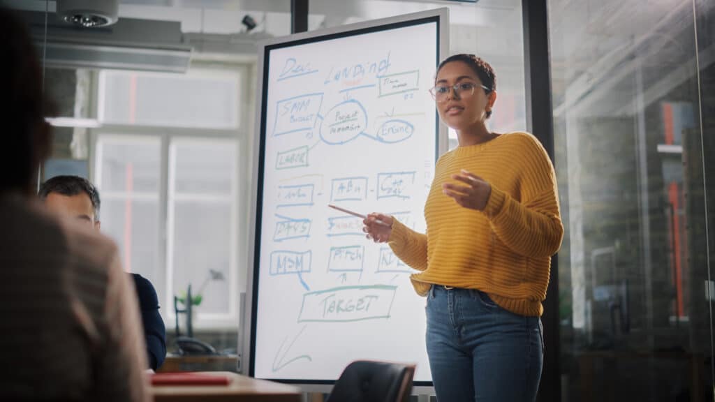 A woman giving a presentation about marketing strategy in an office