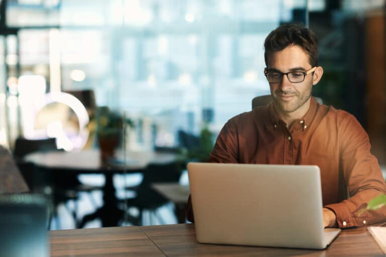 A man sitting down with a laptop.